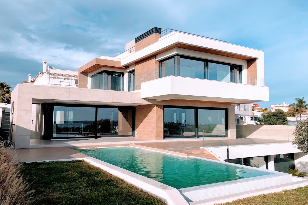 Comparison of a real estate photo before and after one-click AI editing: flat sky replaced, exposure corrected, clutter removed